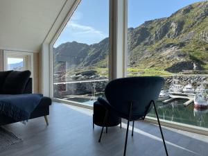 a room with a large window with a view of a harbor at High standard Lodge Ballstad in Ballstad +36 photos