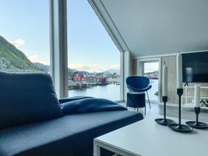 a living room with a couch and a large window at High standard Lodge Ballstad in Ballstad