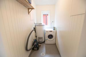 małą łazienkę z pralką i pralką w obiekcie High standard Lodge Ballstad w mieście Ballstad