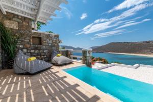 a villa with a pool and a view of the ocean at Panormos Village Hotel in Mykonos