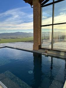 uma piscina ao lado de um edifício com janelas em La Valle del Re - Agriturismo em Medesano