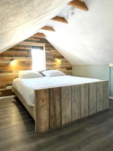 een slaapkamer met een groot bed en een houten muur bij Het Zwaluwnest in De Vecht