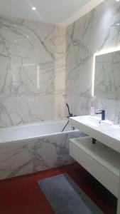 a white bathroom with a sink and a mirror at Mas de la Sorgue - Rendez-vous en Provence in Bédarrides