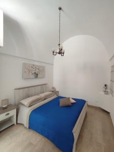 - une chambre avec un lit bleu et un lustre dans l'établissement Casa Indelli, à Monopoli
