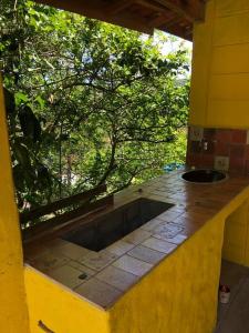 eine Außenküche mit einem Waschbecken in einem Haus in der Unterkunft Casa Tupa Recanto Familiar Pague 2 Minimo e fique 3 menos feriados in Natividade da Serra