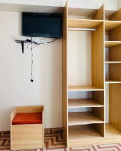 a room with a tv and a book shelf at LA CASONA DE YANAHUANCA in Yanahuanca