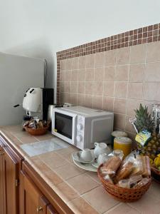 un bancone cucina con forno a microonde e un cesto di pane di I trulli del Sole a Martina Franca