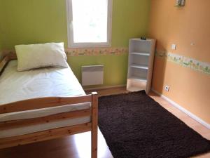 1 dormitorio con cama, ventana y alfombra en Maison proche de plage, 3 chambres en La Rochelle