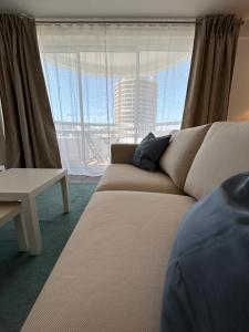 uma sala de estar com um sofá e uma grande janela em Praia da Rocha Torre Verde - Portimao em Portimão
