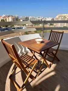 uma mesa de madeira e 2 cadeiras numa varanda em Praia da Rocha Torre Verde - Portimao em Portimão