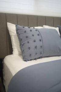 a white bed with a blue pillow on it at Long Stay Luxury New Spacious Apartment - Sleeps 6 in Kitchener