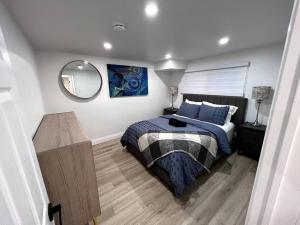 1 dormitorio con cama y espejo en Long Stay Luxury New Spacious Apartment - Sleeps 6, en Kitchener