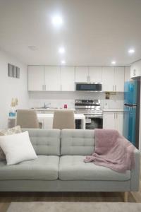 sala de estar con sofá y cocina en Long Stay Luxury New Spacious Apartment - Sleeps 6, en Kitchener