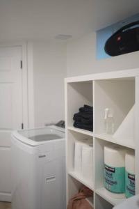 a white cabinet filled with toilet paper and towels at Long Stay Luxury New Spacious Apartment - Sleeps 6 in Kitchener