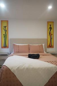 1 dormitorio con 1 cama grande y 2 cuadros en la pared en Long Stay Luxury New Spacious Apartment - Sleeps 6, en Kitchener