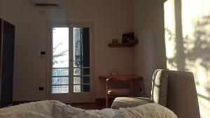 ein Schlafzimmer mit einem Bett, einem Stuhl und einem Fenster in der Unterkunft Madina Apartments - Dokki in Kairo