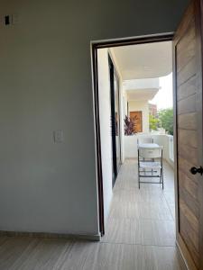 pasillo con puerta, mesa y silla en Departamento Marsopas a 5 minutos a pie de Bahía Carrizalillo!!! 5, en Puerto Escondido