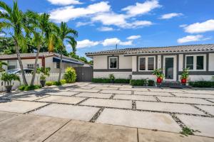 une maison avec des palmiers dans l'allée dans l'établissement Little Gables Studio-Your Miami Escape-10min Airport, à Miami