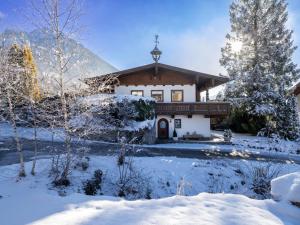 ein Haus im Schnee mit schneebedeckten Bäumen in der Unterkunft Ferienwohnung Lentner in Maurach