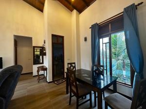 a dining room with a table and chairs and a window at Sagya Residencies in Panadura