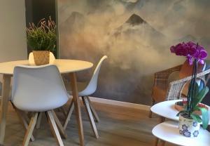 une chambre avec deux tables et des chaises ainsi qu'une fresque murale sur la montagne. dans l'établissement El Cau de Ribes, à Ribes de Freser