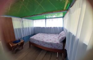 a small bedroom with a bed and a window at Refugio Rural Amazonas in Iquitos
