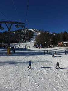 a group of people skiing down a ski slope at La Baita Residence 3.0 in Folgarida