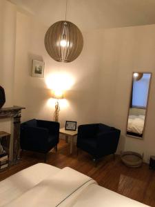 a bedroom with a bed and two chairs and a lamp at La couque cuivrée in Dinant