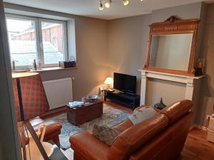 a living room with a leather couch and a mirror at La couque cuivrée in Dinant