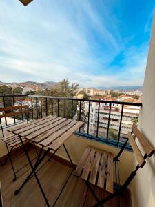 un banco de madera sentado en un balcón con vistas en Cosy Trinidad, en Málaga