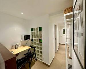 eine kleine Küche mit einem Schreibtisch und einer Mikrowelle in der Unterkunft T6 Apartamento con terraza y sol! A 1`del metro in Barcelona