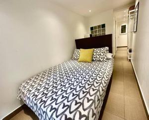 ein Schlafzimmer mit einem schwarz-weißen Bett in einem Zimmer in der Unterkunft T6 Apartamento con terraza y sol! A 1`del metro in Barcelona
