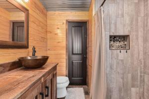 ein Badezimmer mit einem Waschbecken und einer Holzwand in der Unterkunft 5 Bedroom Waterfront Home on LKG in Henrico