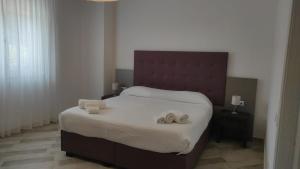 La Perla del Tirreno Guest House في سابري: غرفة نوم بسرير كبير عليها نعال