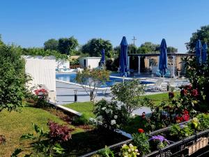 un jardin avec des parasols bleus et une piscine dans l'établissement Le Domaine Green Paradise, à Ulcinj