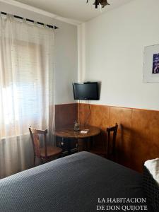 a bedroom with a bed and a table with a television at Casa de la Mancha in Mota del Cuervo