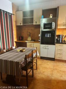a kitchen with a table with chairs and a microwave at Casa de la Mancha in Mota del Cuervo