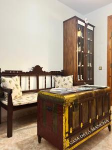 a bedroom with a wooden bed and a wooden trunk at Casa rural compartida Casa de la Mancha in Mota del Cuervo +17 photos
