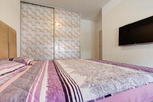 a bedroom with a large bed with a flat screen tv at DiVino Apartment in Tivat