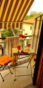 un balcón con una mesa con dos rosas rojas. en Little Home, en Bolsena