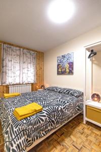 um quarto com uma cama com um edredão preto e branco em La Mia Valigia “Casetta Fragolina” em Camigliatello Silano