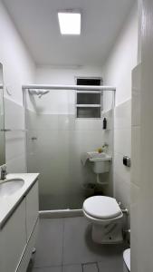 a white bathroom with a toilet and a shower at house JV in Rio de Janeiro