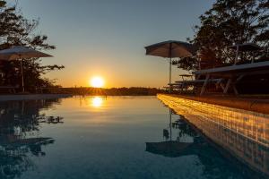 een zwembad met een zonsondergang op de achtergrond bij Villa ALTA in Villastrada