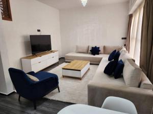 Residence Al Kasbah - VacayX - Chic Triplex 3BR -RABAT في الرباط: غرفة معيشة مع أريكة وتلفزيون