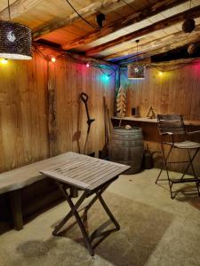 LAC ABANE AU LAC في بوتغينباخ: غرفة خشبية فيها جلسة وطاولة وبرميل