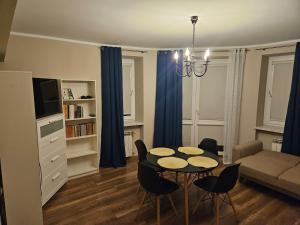 een woonkamer met een tafel en stoelen en een bank bij Apartament blisko jeziora in Ełk