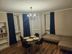 sala de estar con sofá, mesa y sillas en Apartament blisko jeziora, en Ełk