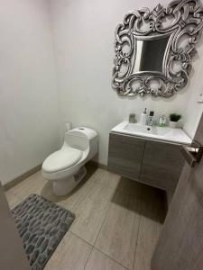uma casa de banho com um WC e um espelho na parede em Cozy Oasis with Panoramic Views em Cerritos
