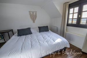 a white bed with two pillows on it in a bedroom at Le Refuge du Bois d'Amour in Arnières-sur-Iton +26 photos