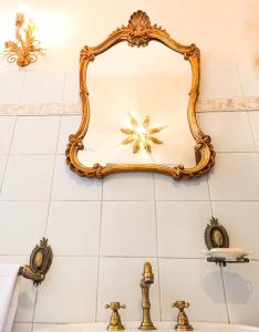 - un miroir au-dessus d'un lavabo dans la salle de bains dans l'établissement Renaissance Suite, à Ferrare